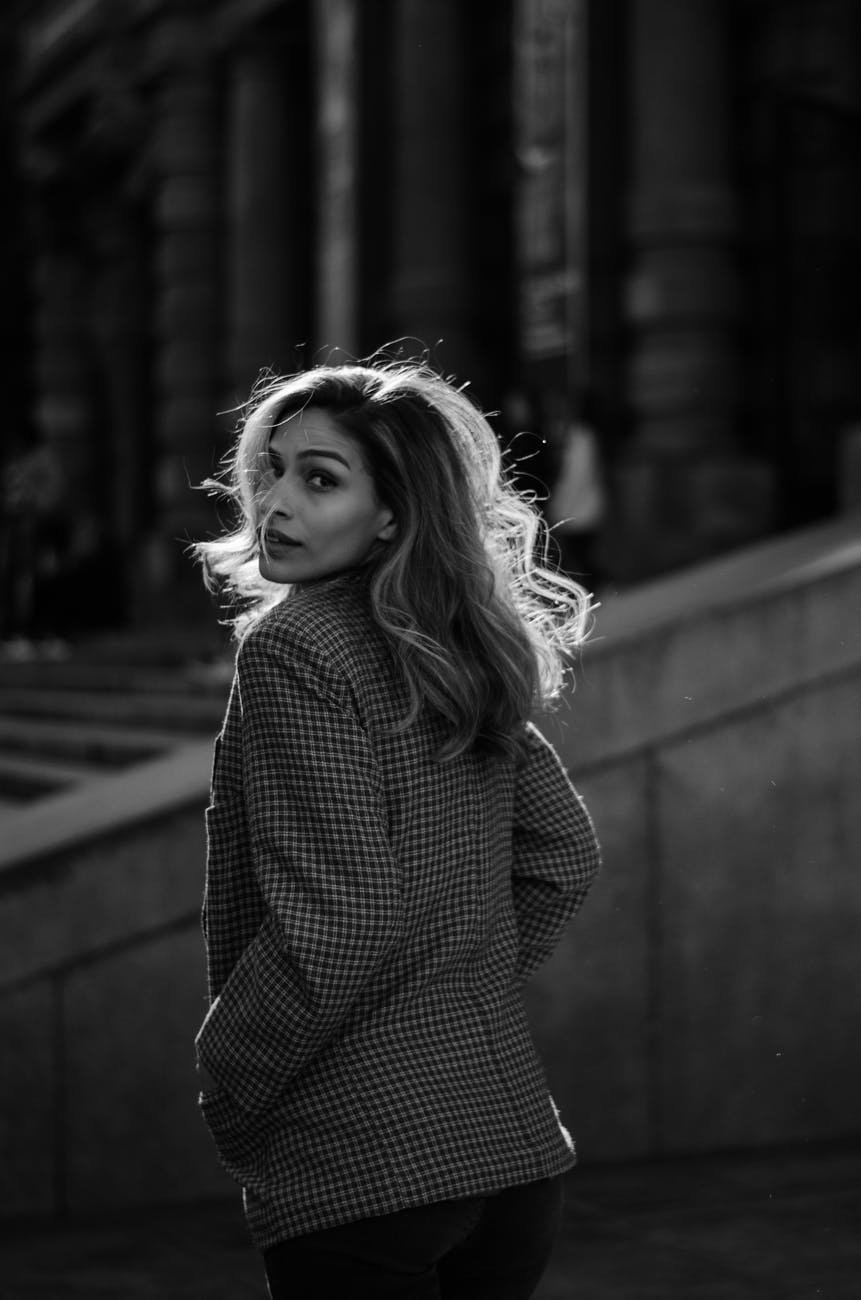 Une jeune femme se retourne vers nous, pendant sa visite guidée d'une ville européenne.