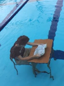 Au fond d'une piscine, une personne lit à un bureau